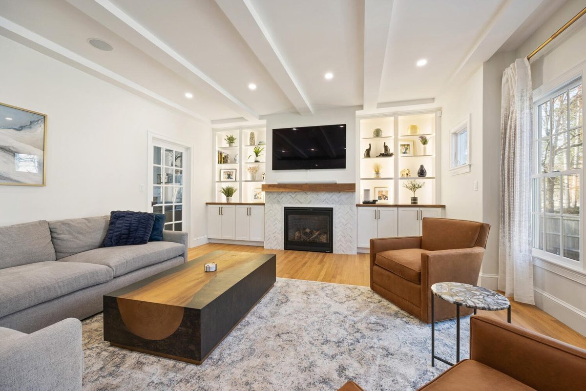After: Living room: a gas fireplace insert, built-ins and wood beams.