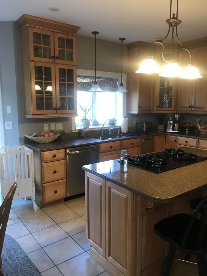 Before: Kitchen: the old layout with a cooktop island became an open kitchen with a range wall and two sinks.