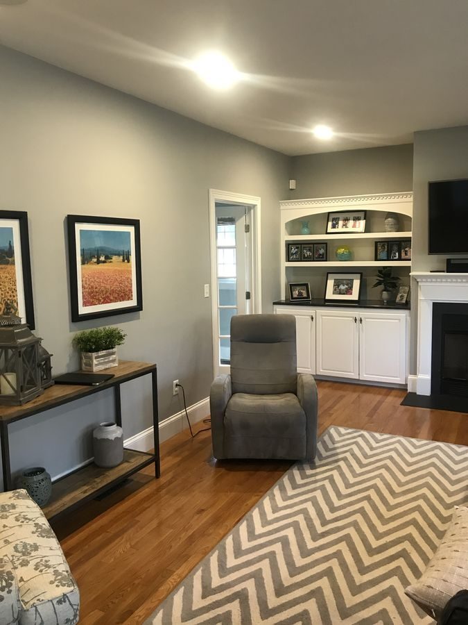 Before: Living room: a gas fireplace insert, built-ins and wood beams.