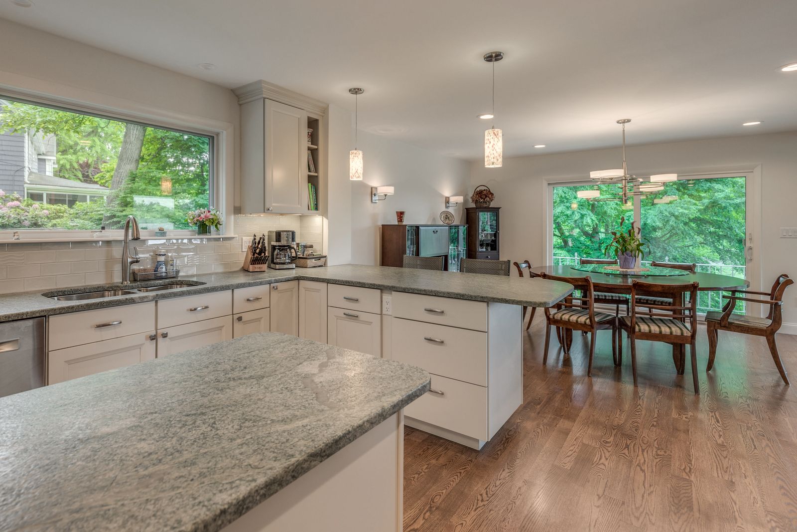 Open kitchen looking past the island and peninsula to the dining area and sliding doors