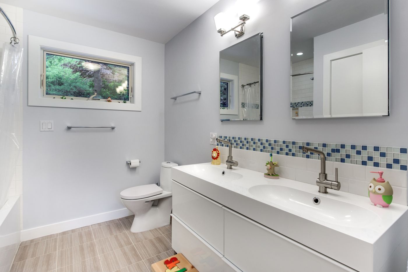 After: Bath: a dated tub bath became a bright bath with a wide double-sink vanity and a band of glass mosaic tile.