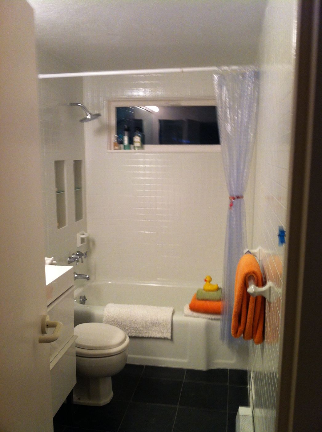 Before: Bath: a dated tub bath became a bright bath with a wide double-sink vanity and a band of glass mosaic tile.