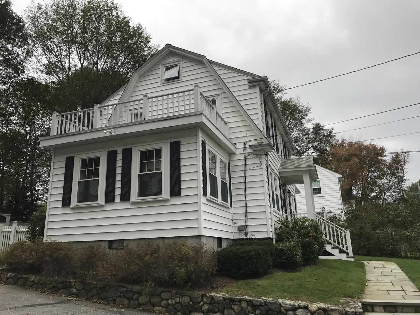 Before: Outside: the one-story side wing with a rooftop railing became a full two-story addition that matches the house.