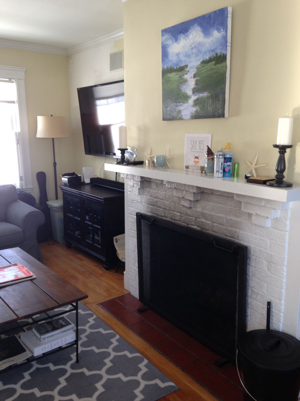 Before: Fireplace: the painted brick surround was refaced in dark slate tile with a wood mantel, now anchoring a dining area open to the kitchen.