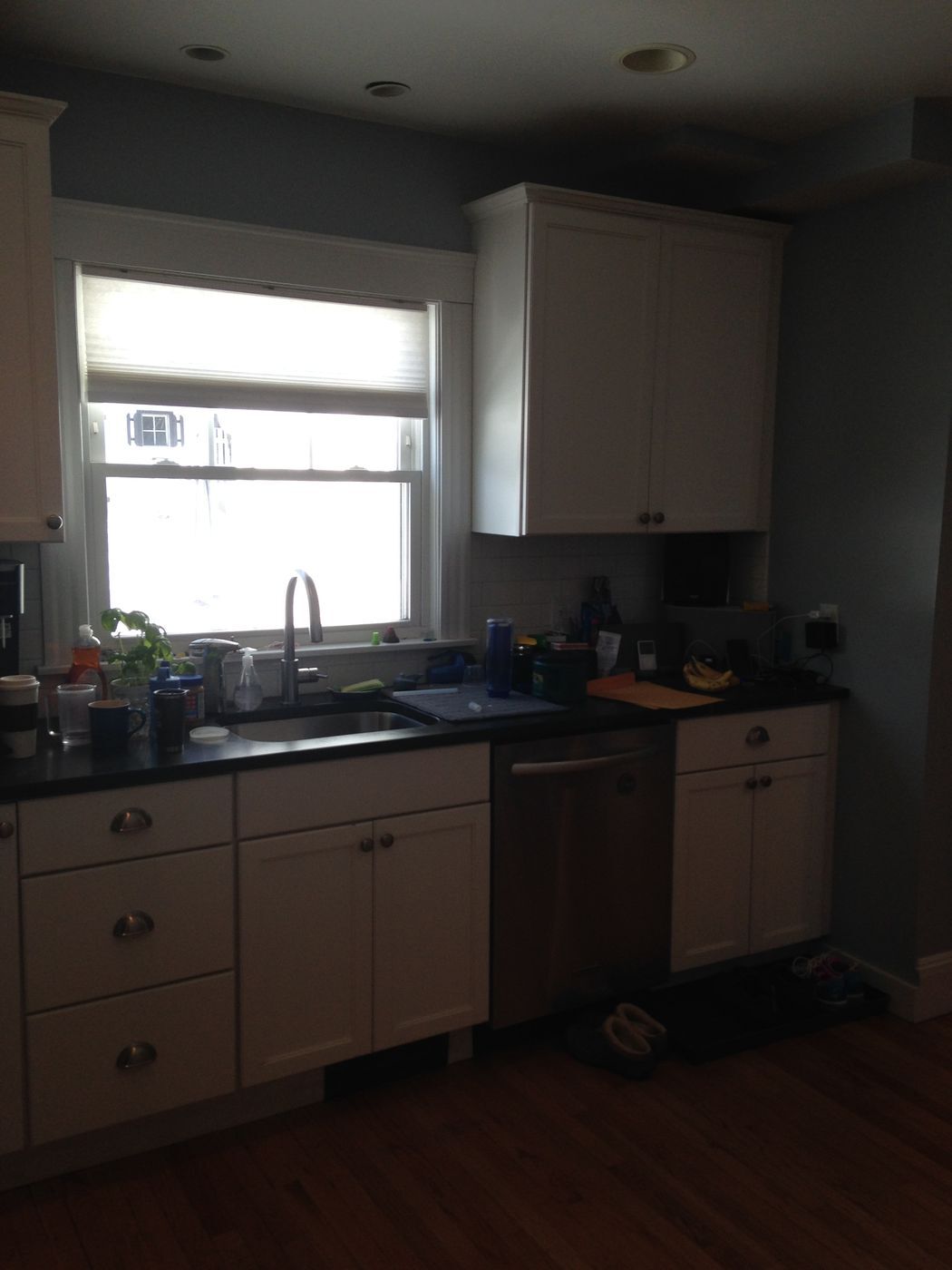 Before: Kitchen: the sink stayed under the back window, with new shaker cabinets, a marble backsplash, a gas cooktop and a stainless hood.