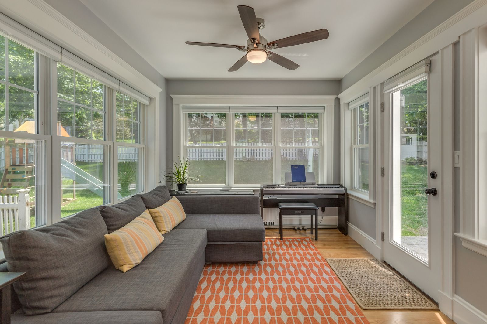 Sunroom bump-out with windows on three sides and a door to the backyard patio
