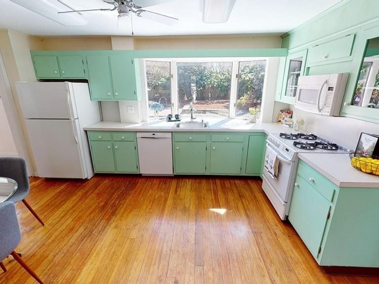 Before: Kitchen: painted cabinets and a freestanding range gave way to natural maple flat-panel cabinets, a stone-topped island and a gas rangetop under a chimney hood, with the sink still facing the garden.