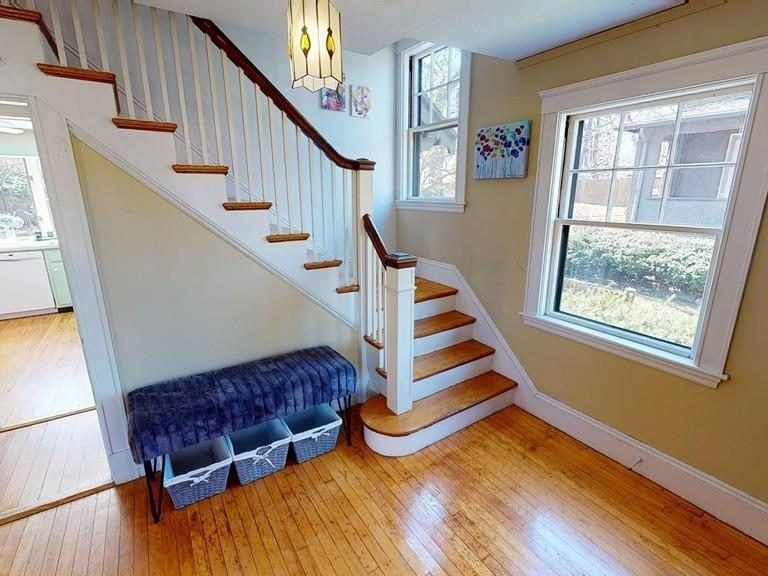 Before: Front hall: the closed-in entry now opens to the kitchen, with a rebuilt stair of oak treads and black balusters and a tile floor.