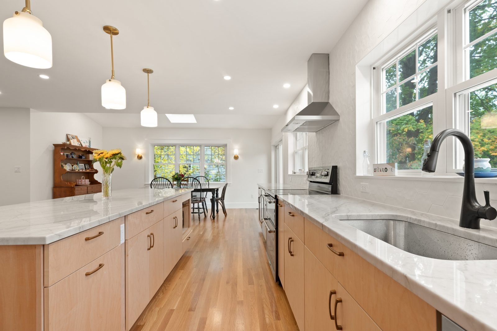Maple slab-door cabinets, quartzite counters and an undermount sink under a row of double-hung windows