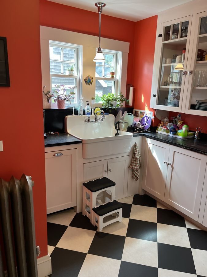 Before: Kitchen: a tight corner sink under two small windows became a farmhouse sink under a wide window, with quartzite counters and a view through to the new mudroom.
