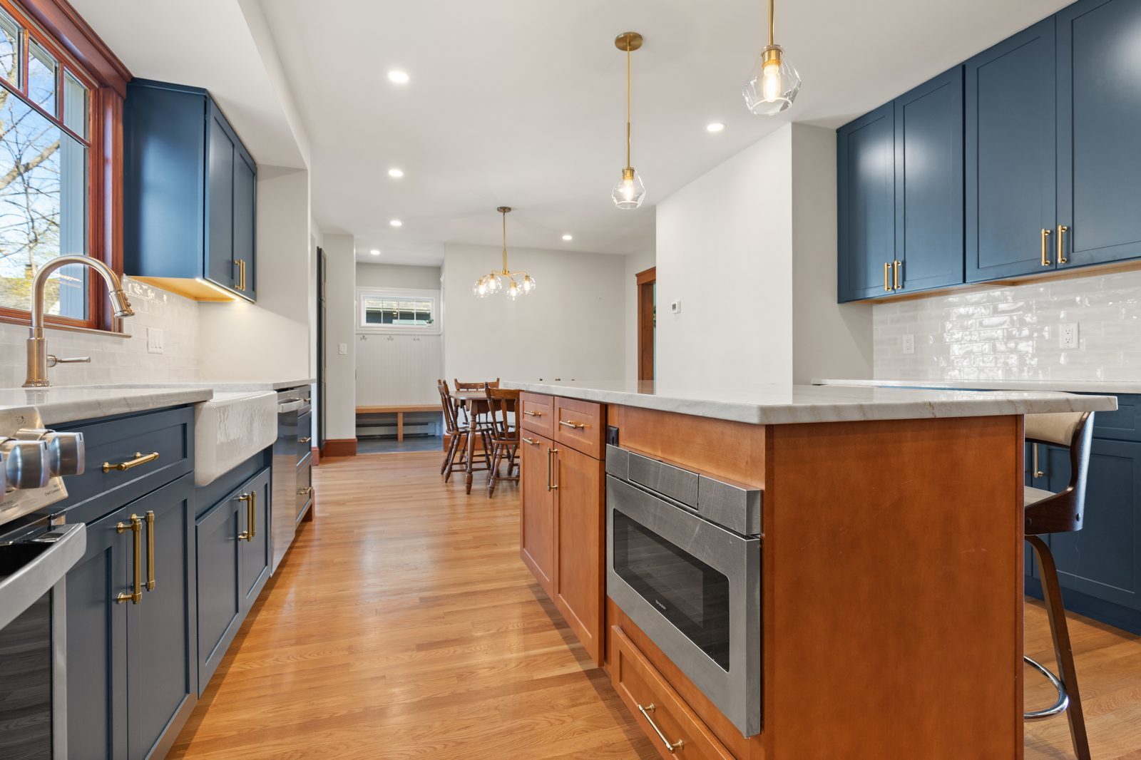 Kitchen island and blue cabinets looking toward the new mudroom