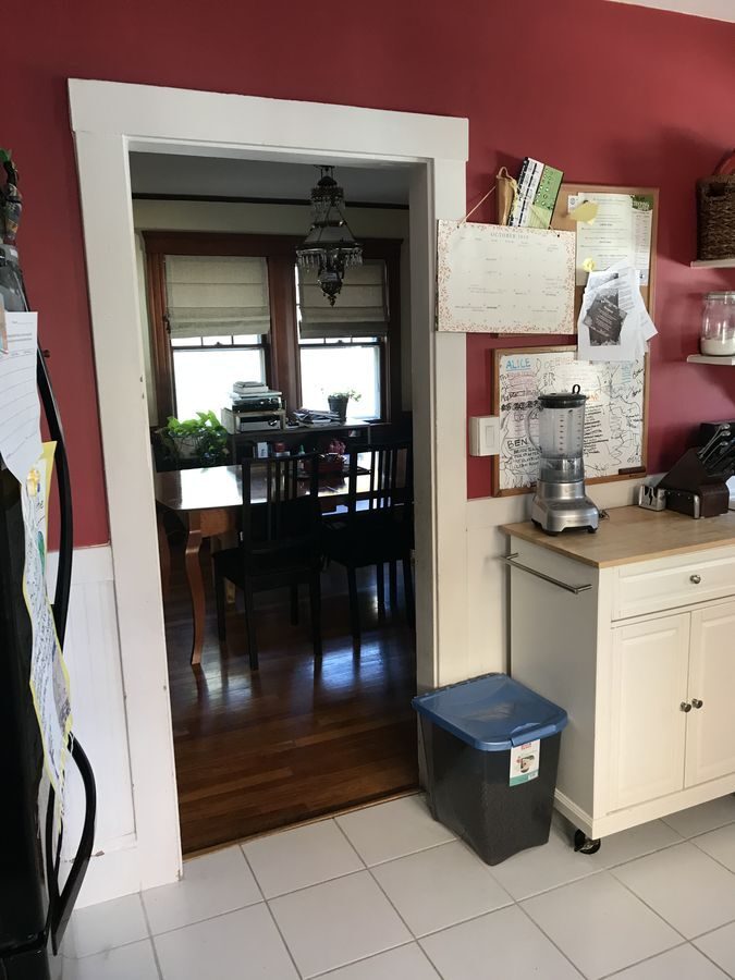 Before: Kitchen to dining room: a single doorway became a wide opening with a peninsula and built-in microwave, and oak floors now run from room to room.