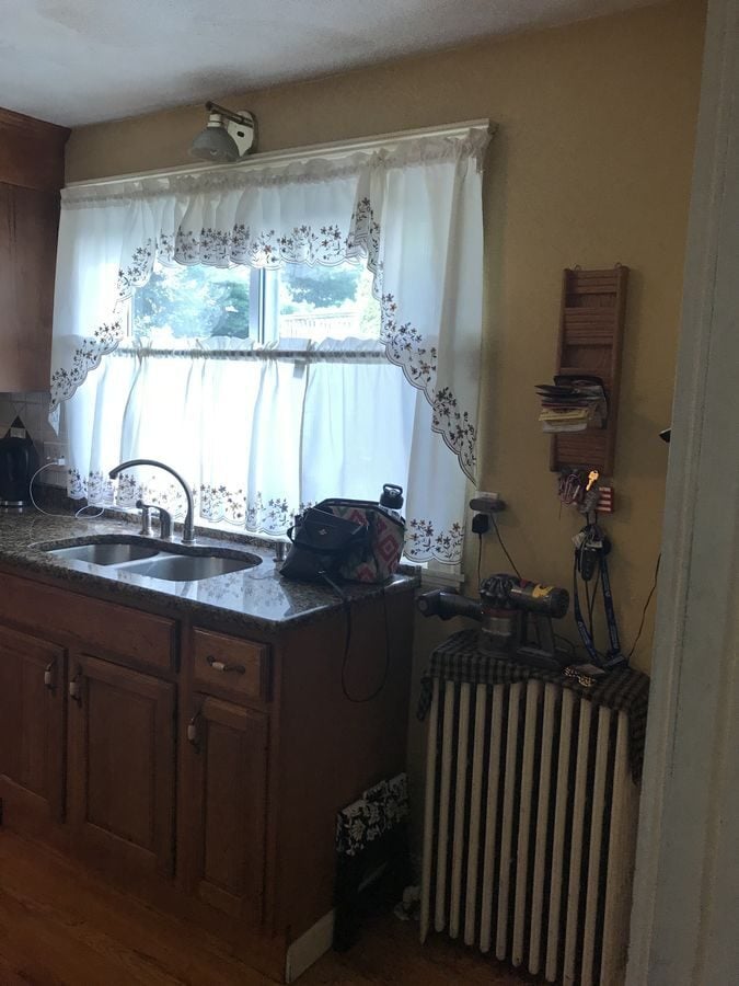 Before: The old sink window wall became a cooktop wall with two windows, a custom wood hood and a patterned marble backsplash.