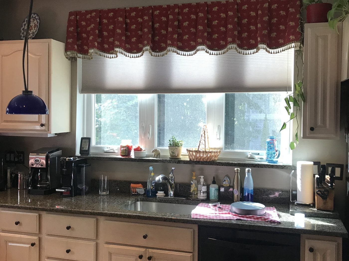 Before: dark granite and raised-panel cabinets at a Melrose kitchen sink window