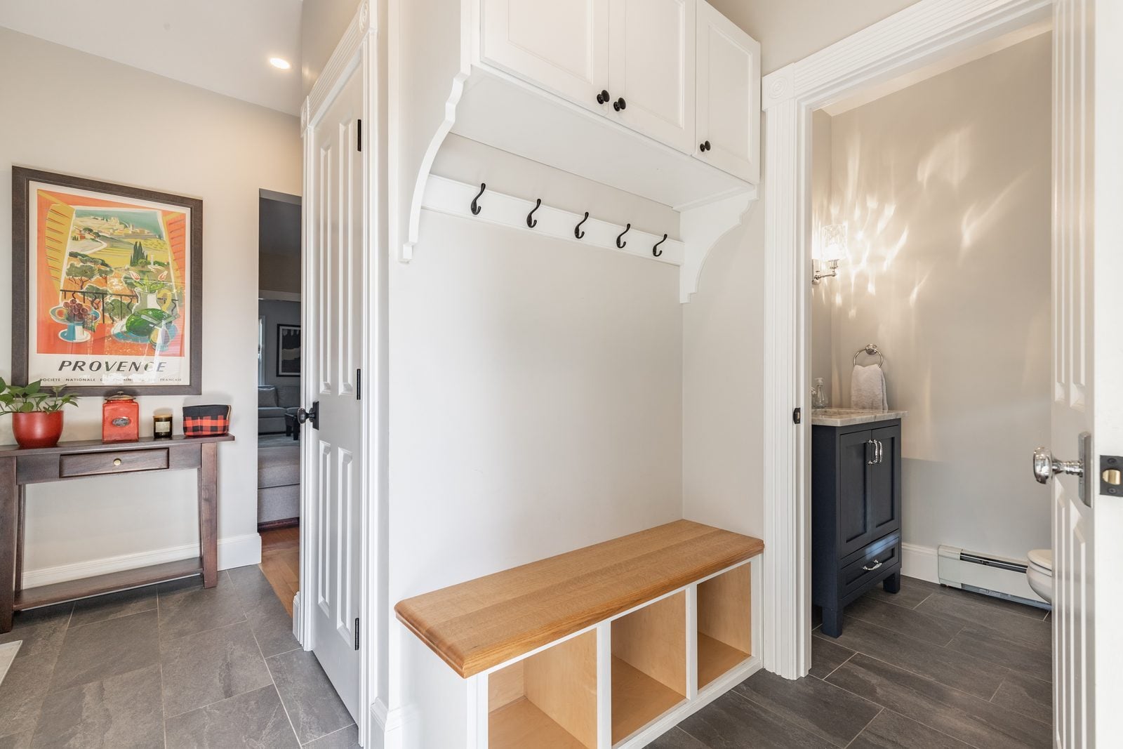 Mudroom with built-in bench, cubbies, hooks and upper cabinets