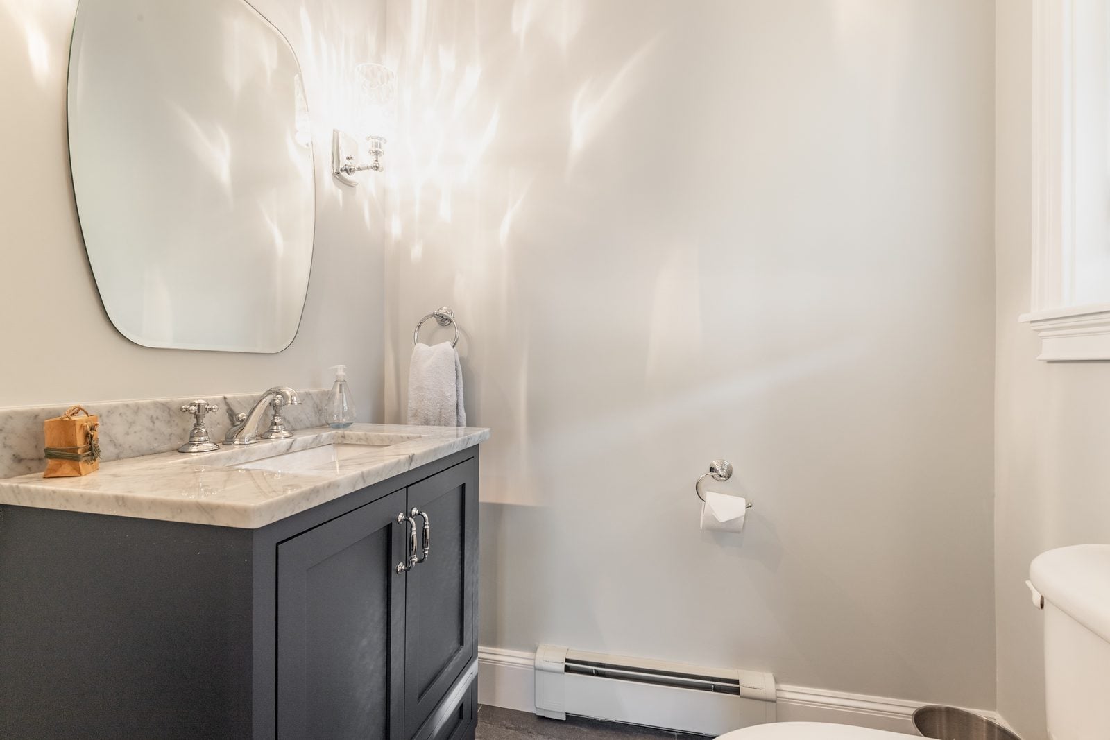 Powder room with navy vanity and marble top