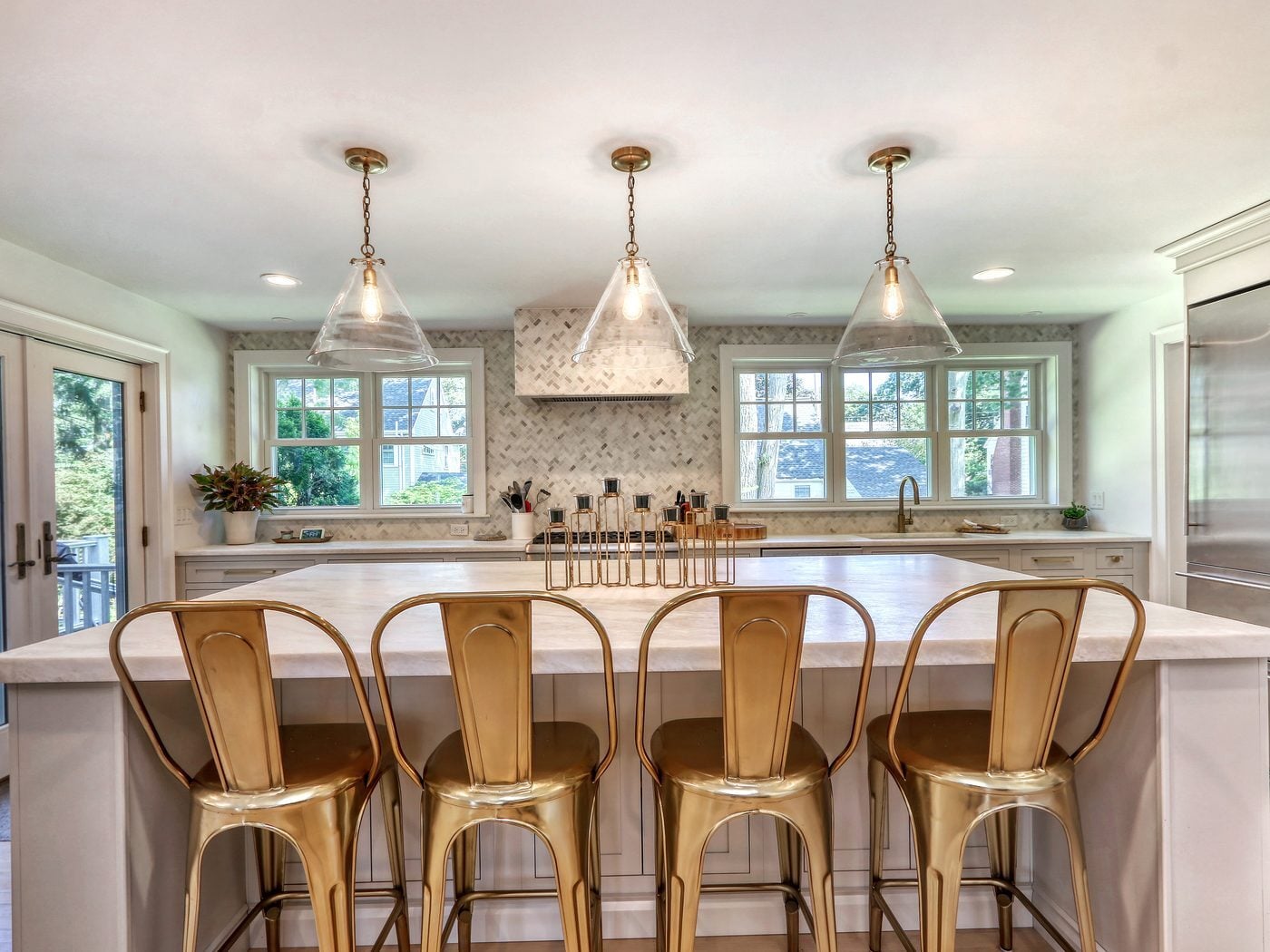 After: Kitchen to deck: the cramped corner by the fridge and French doors opened into a long island with seating for four and a clear path out to the deck.