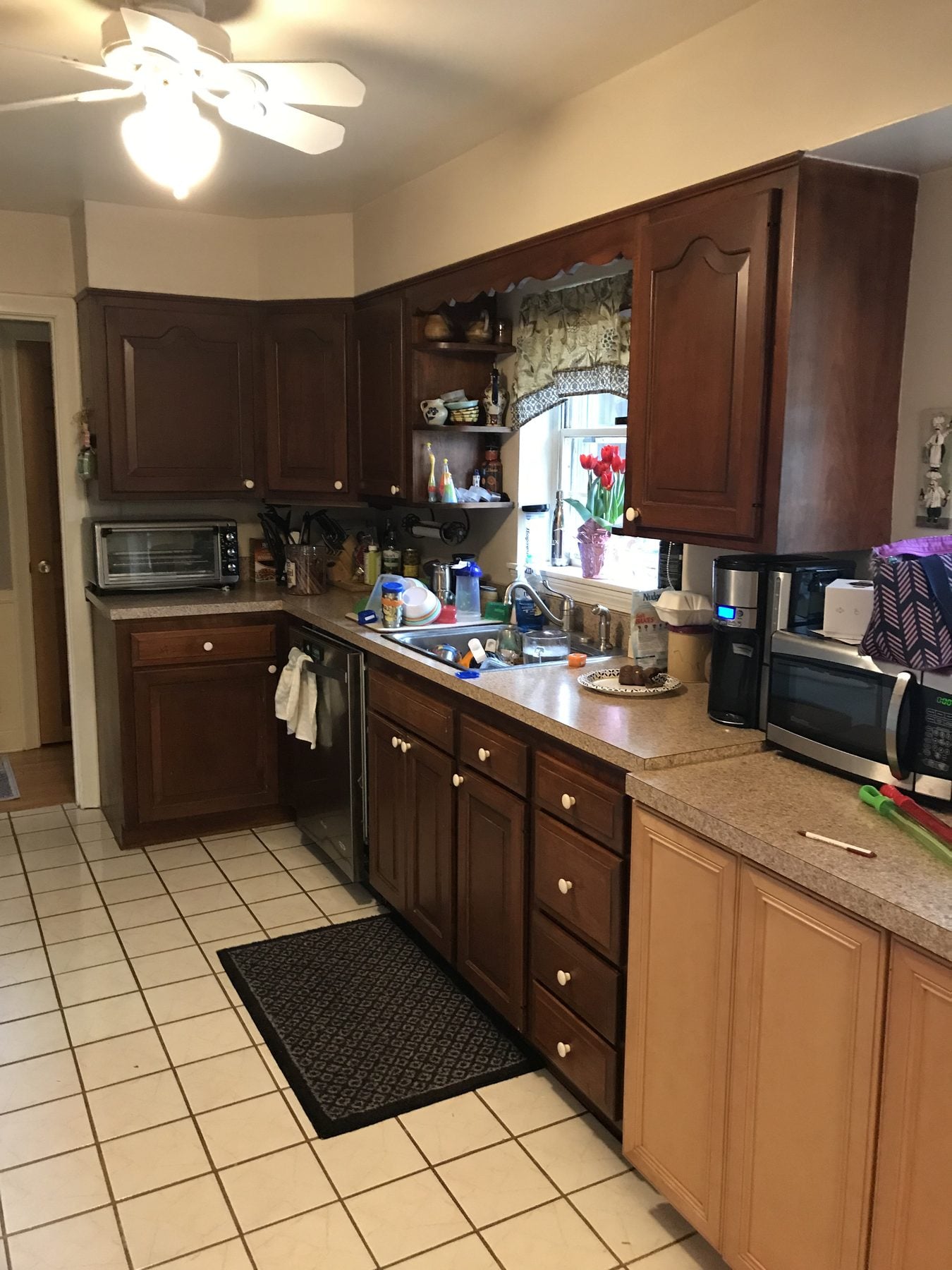 Before: Kitchen: dark cabinets, laminate counters and a tile floor replaced by stained maple cabinets, quartz counters, a stainless farmhouse sink, a stone backsplash and oak floors.