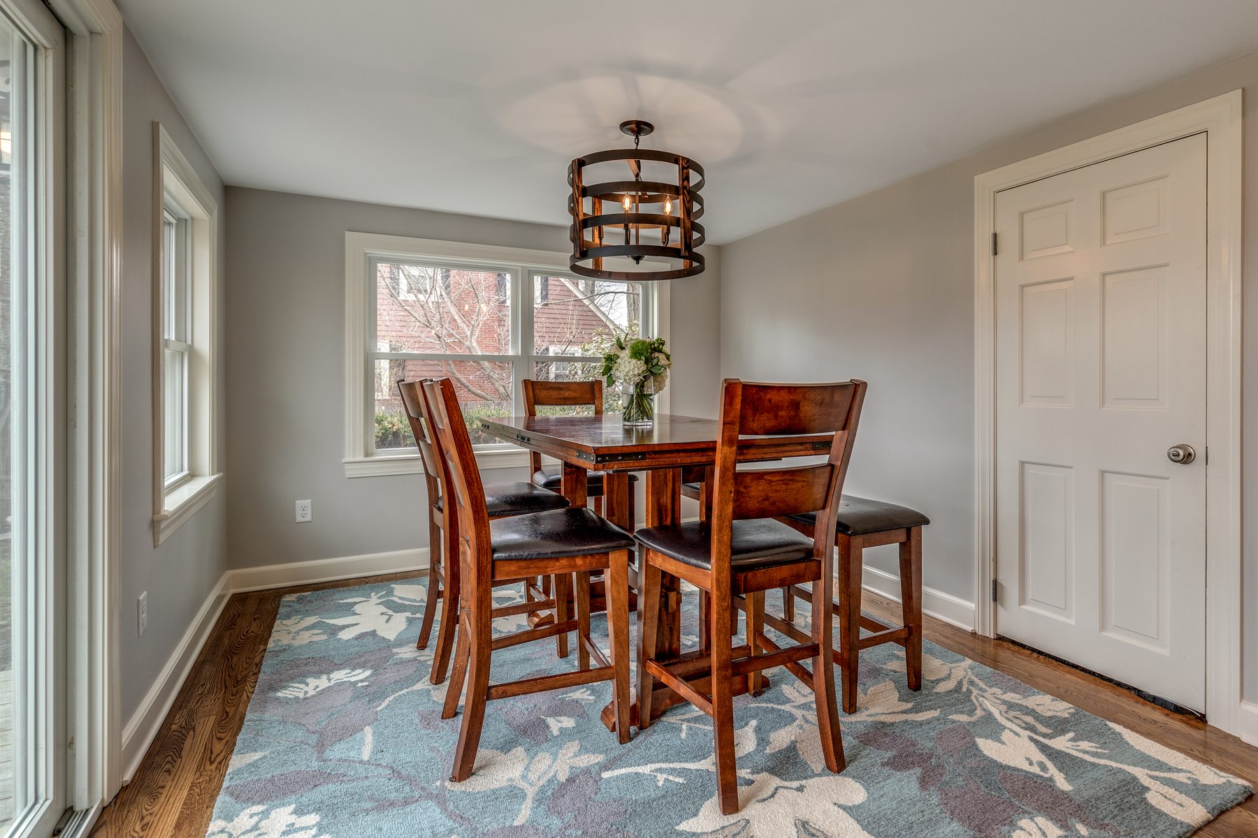 Dining area in the former sunroom with oak floors and windows on two walls in Wakefield, MA