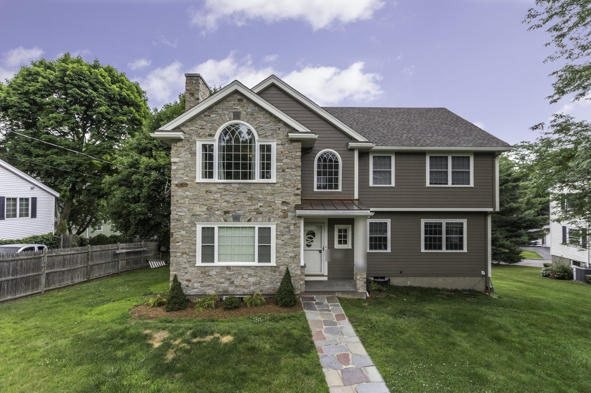 Two-story Winchester home with a stone-faced gable